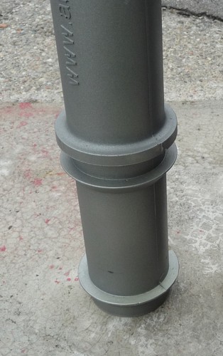Grauer Metallpfosten auf Betonboden