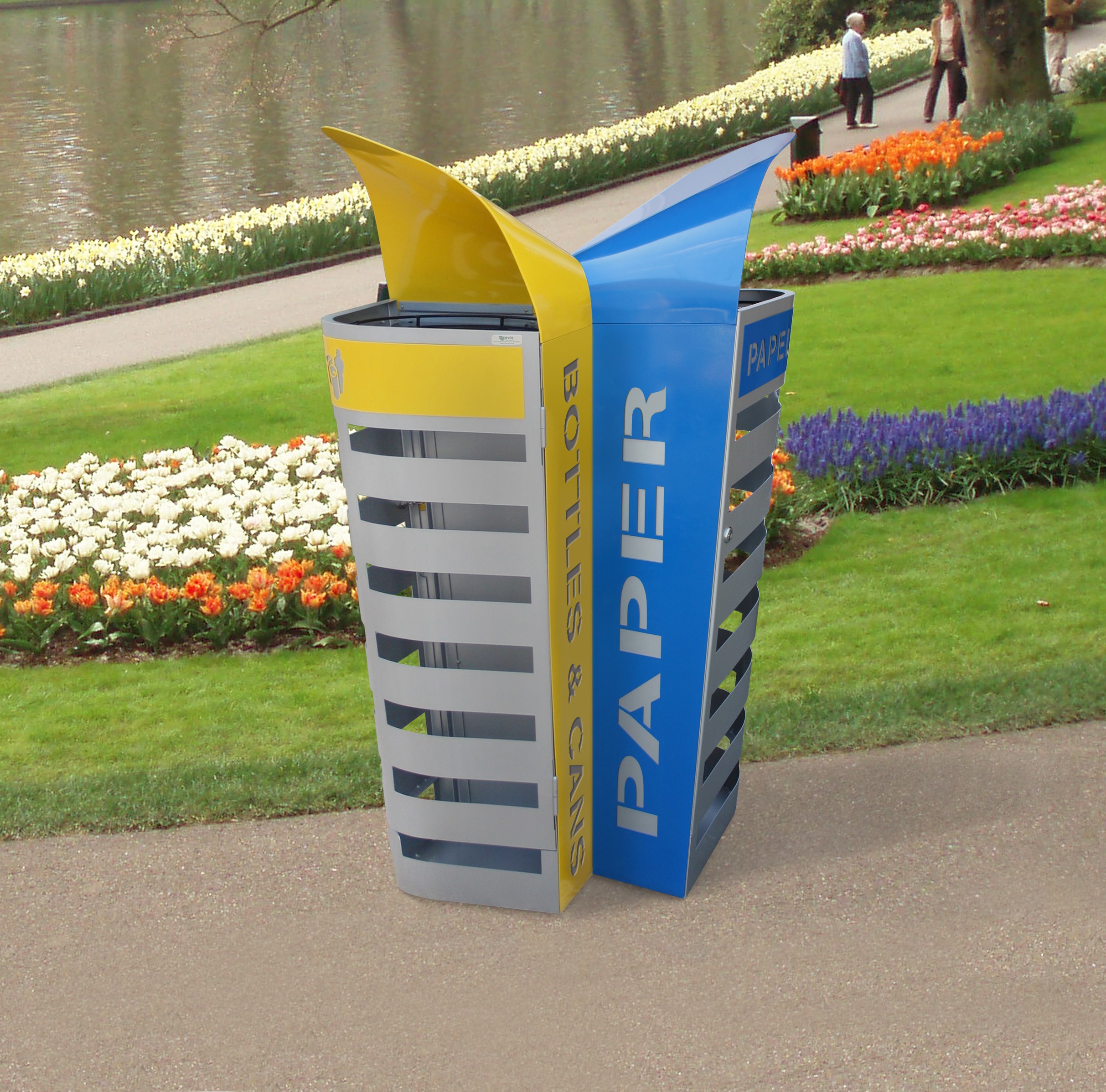Zwei Recyclingbehälter im Park, einer für Papier und einer für Flaschen und Dosen, umgeben von Blumenbeeten.