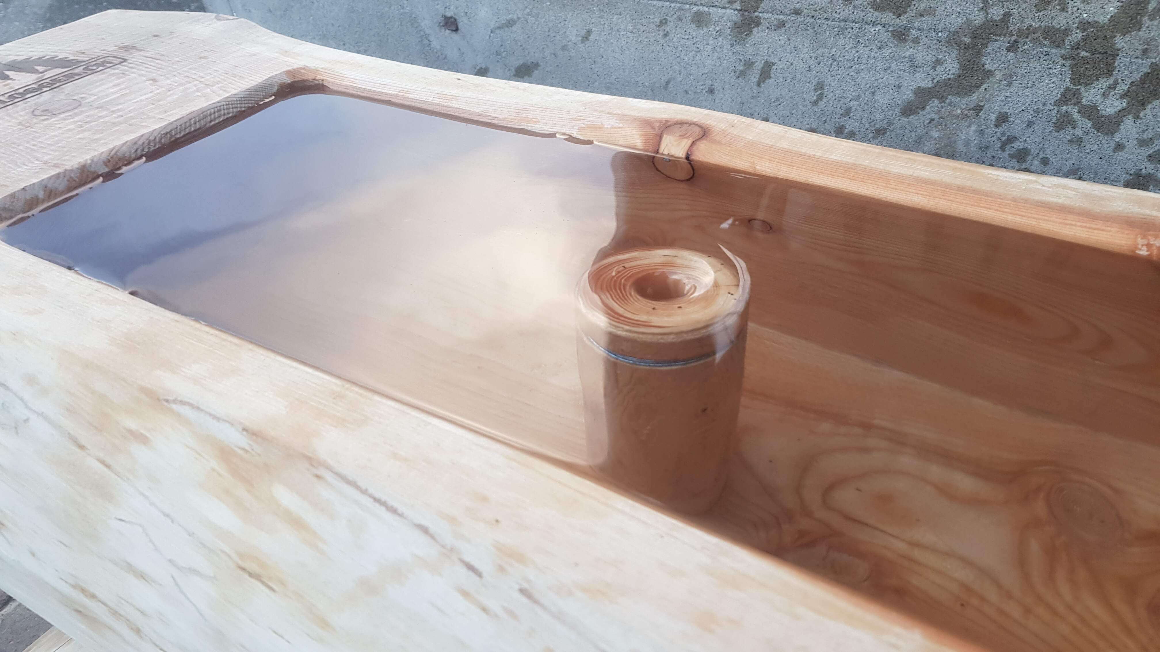 Table en bois massif avec remplissage en résine époxy transparente qui présente une structure de tronc de bois naturelle