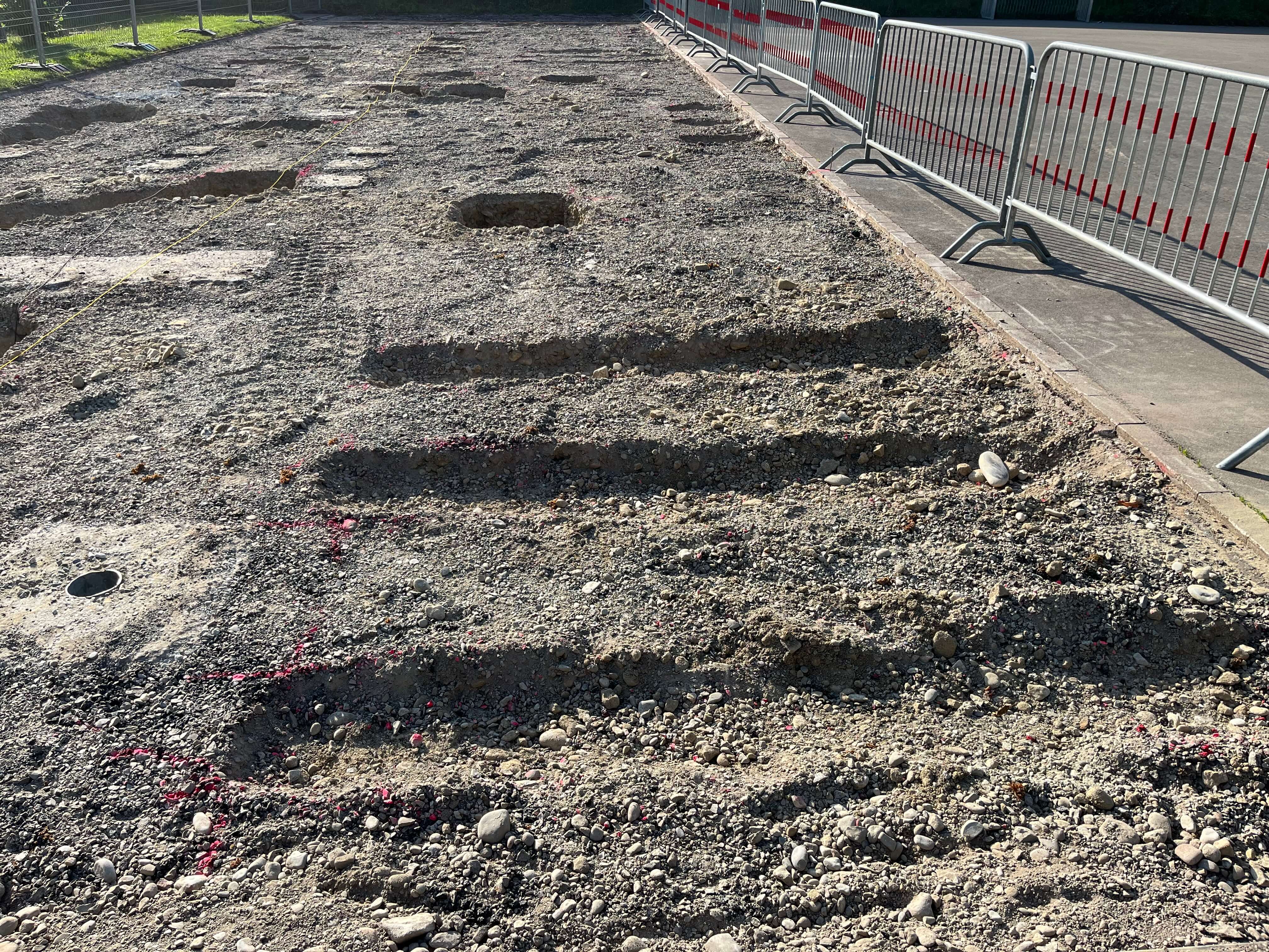 Eine Baustelle mit ausgehobenem Erdreich und Absperrgittern an der Seite