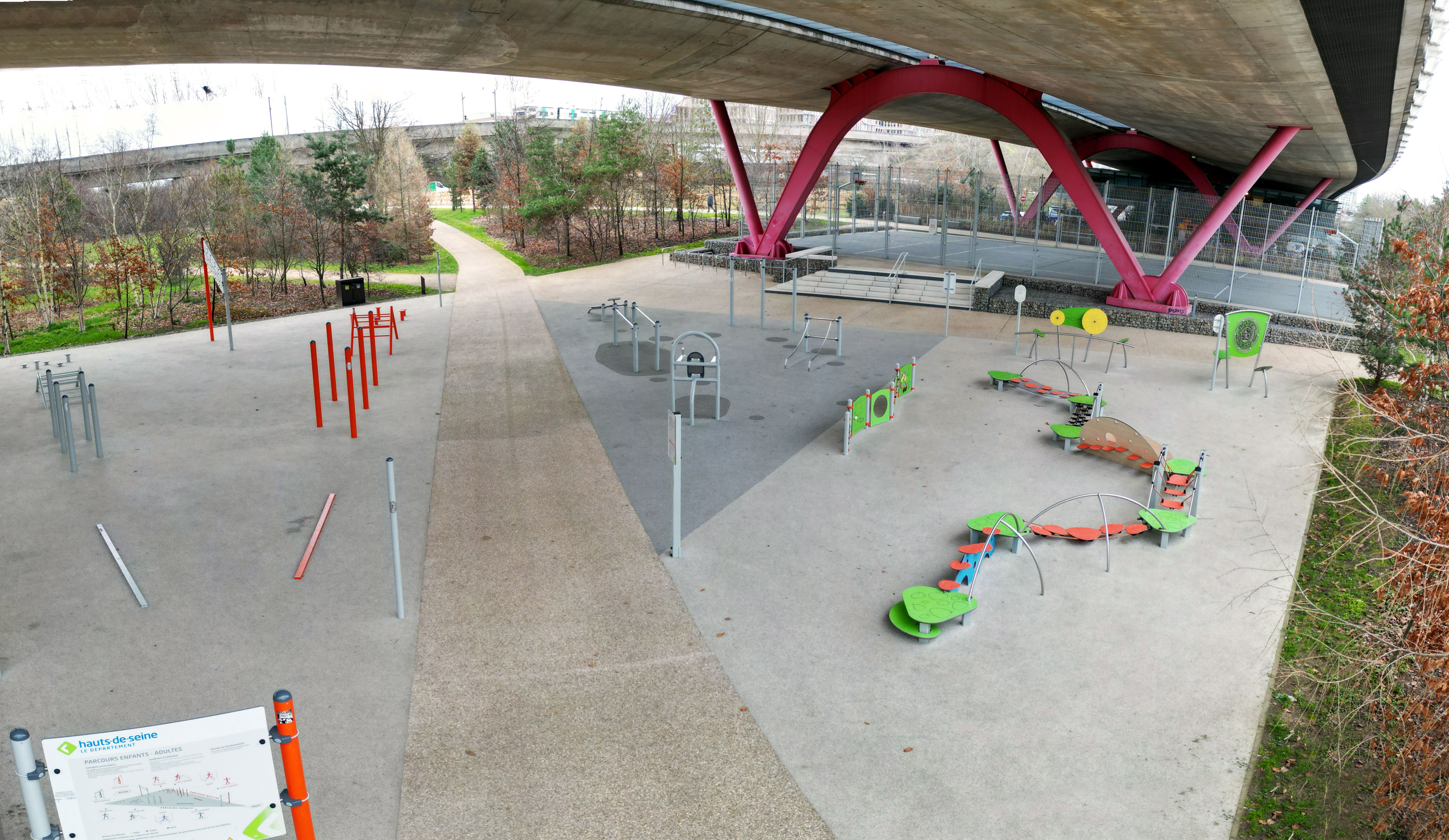 Aktivitätsbereich unter einer Brücke mit verschiedenen Fitness- und Spielgeräten
