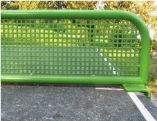 Nahaufnahme eines grünen Tischtennisnetzes auf einem Outdoor-Tisch mit Hintergrund aus Bäumen und Gras