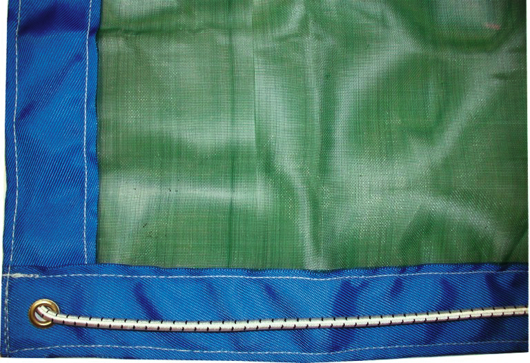 Gros plan sur un filet bleu et vert avec un œillet et une cordelette passée au travers