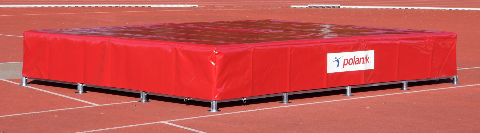 Rote Hochsprungmatte mit Polanik-Logo auf Sportplatz