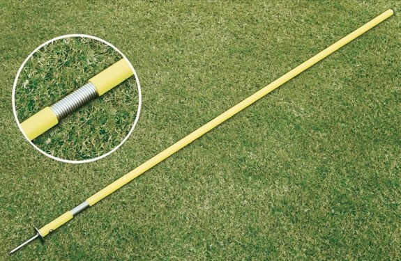 Gelbe Markierungsstange mit Feder und Bodendübel auf Rasen für Sportplatz