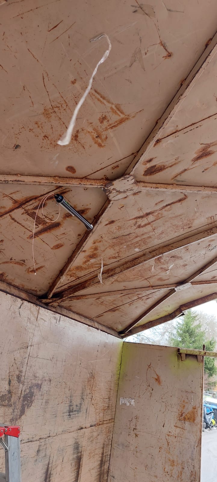 Blick in einen rostigen Container mit einem an der Decke befestigten Stift