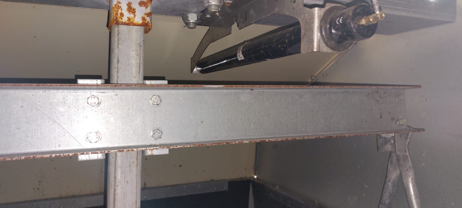Detailansicht eines Metallträgers mit Schrauben und Rostflecken