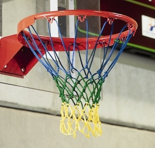 Detailaufnahme eines Basketballkorbs mit mehrfarbigem Netz in einer Sporthalle