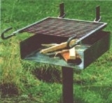 Gartengrill mit integriertem Kohlefach und Holzgriff auf Wiese