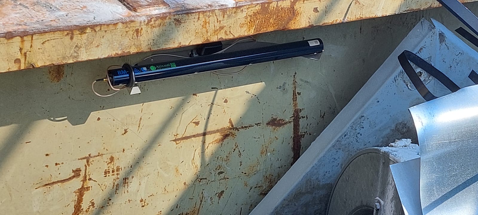 Detailansicht eines rostigen Metallcontainers mit einer an der Wand befestigten Wasserwaage