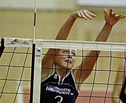 Eine Volleyballspielerin in Trikot mit der Nummer 2 springt am Netz, um den Ball zu blocken.
